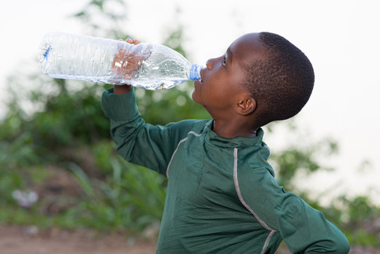 portrait of a little boy drinking water.