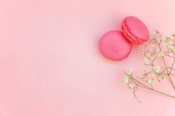 Top view of mini pink macaron or macaroon french desserts cake on soft sweet pink pastel paper flat lay background