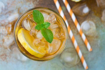 Traditional iced tea with lemon, mint and ice in tall glasses. A glass of refreshing summer drink...