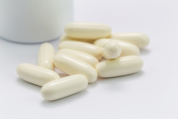 Pills and pills bottle on white background.