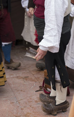A man wearing traditional costume is pouring a bottle of cider