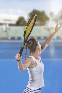 Rear view of tennis player serving during a match