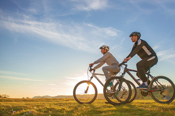Happy mountainbike couple outdoors have fun together on a summer afternoon sunset © FS-Stock