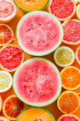 Citrus background, wallpaper with citrus orange lemon and grapefruit around two half of watermelon
