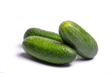 Fresh small green cucumbers close up copy space isolated on white background