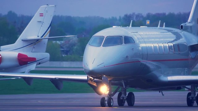 Business jet rides the the runway after landing at dawn. Front view