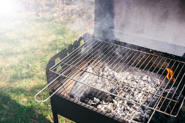 Grill with burning coals ready for barbecue outdoors