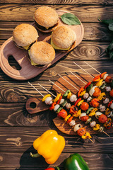 Table with vegetables and burgers grilled for outdoors barbecue