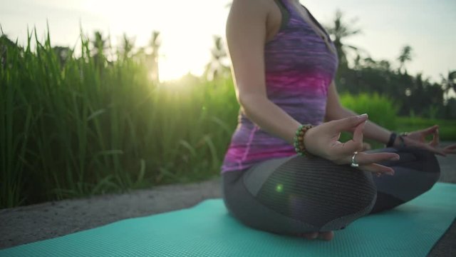 Yoga woman meditating in rice field with hands in mudra rapid slow motion