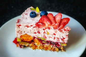 Piece of jelly fruit cake with milk on a white plate