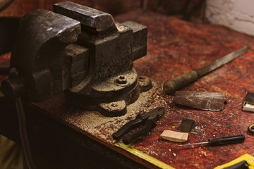 Vices, pliers, files and awls lie on workbench in carpentry workshop. Tool for manual labor