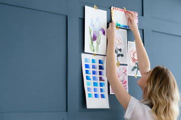 Naklejka premium creative art lifestyle. drawing hobby and self expression. girl sticking her paintings to the wall