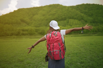 backpack woman open arms with mountain background