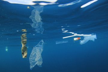 Plastic pollution in ocean. Plastic bags, bottles and straws pollute sea
