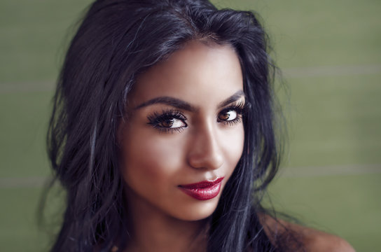 Beautiful young woman with dark exotic looks and long curly hair
