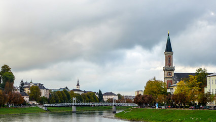 Fototapeta premium view of the bridge over the river with the church near the park