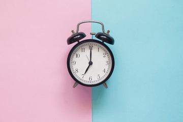 Close up clock on pink and blue background, Pastel colors concept