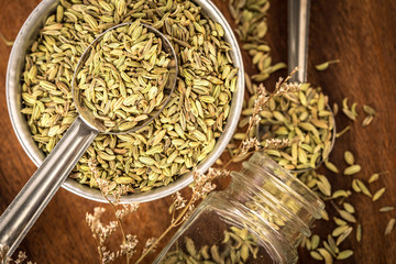 close up  fennel seed in  spoon on brown wooden table