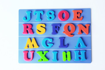 plastic magnetic colored english alphabet on blue background