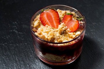 dessert with fresh strawberries, biscuits and cream on dark background