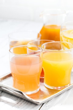 fresh citrus juices in glasses, vertical