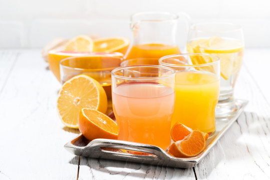 fresh citrus juices on white table, closeup