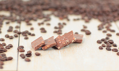 black coffee beans and chocolates on wooden background