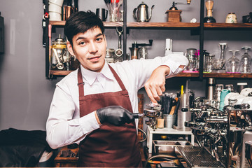 Man Barista using coffee machine for making coffee in the cafe