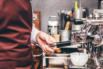 Man Barista using coffee machine for making coffee in the cafe