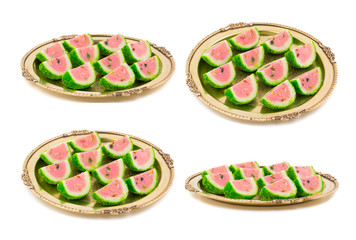 Collage of Indian Sweet Food Watermelon shaped Mawa Barfi in Vintage Golden Plate isolated on white background