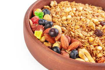 Bowl of homemade granola with fruit pieces isolated on white
