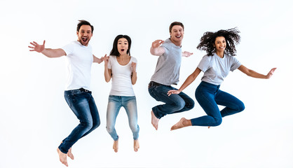 The four happy people jumping on the white background