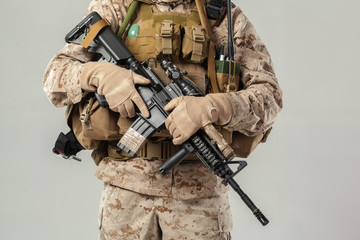 Soldier in camouflage holding rifle