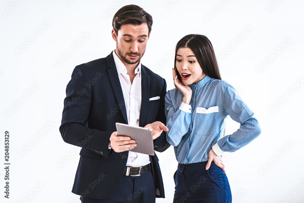 Wall mural The business man and a woman with a tablet standing on the white background