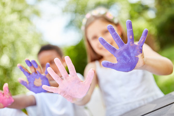 Kinder zeigen ihre bemalten Hände