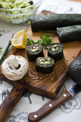Obraz na płótnie Canvas Raw vegan asian rolls with mushrooms, cucumbers, avocado and lemon juice in seaweed. Healthy food.