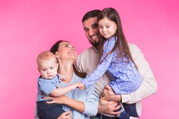 Portrait of Young Happy Mixed Race Family over pink background.
