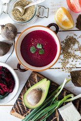Bowl of traditional Russian beetroot soup - borscht. Raw and vegan with tomatoes, avocado, walnuts, parsley, garlic, onion. Vegetarian healthy food. Top view