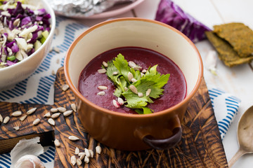 Bowl of traditional Russian beetroot soup - borscht. Raw and vegan with tomatoes, avocado, walnuts, parsley, garlic, onion. Vegetarian healthy food. Top view