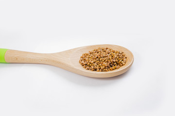 buckwheat in a spoon on white background