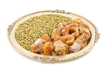 Group of jaggery with Coriander Seeds also Know as Gur, Goor or Gud isolated on White Background