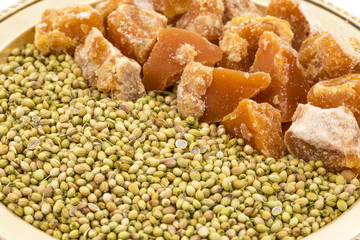 Group of jaggery with Coriander Seeds also Know as Gur, Goor or Gud isolated on White Background