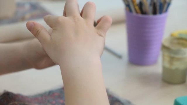 The child learns to mold different kinds of clay products in a ceramic workshop. The child works independently with clay in a lesson in a creative lesson.