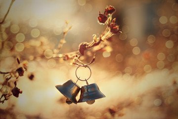 Brass bells hanging from dried flowers