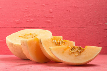 melon (sunlady) slice. half. on wood pink