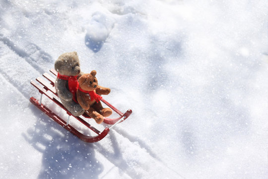 Teddy bears sledding in the winter snow