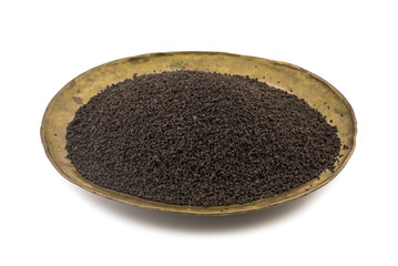 Aromatic Black Tea Loose or Dried Tea Leaves in Vinatge Plate isolated on White Background