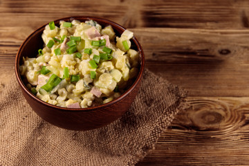 Traditional Russian festive salad Olivier on wooden table