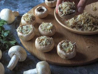 Stuffed mushrooms. Cooking dishes with mushrooms, onions, cheese and herbs. Delicious vegetarian food.