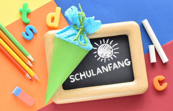 Hintergrund mit Schult&uuml;te oder Zuckert&uuml;te und Text auf Deutsch "Schulanfang"